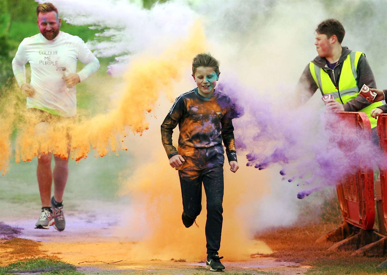 Competitors are pelted with coloured dye during the Colour Me Purple 5km run through Milton Creek Country Park for the Wisdom Hospice. Picture: Phil Lee