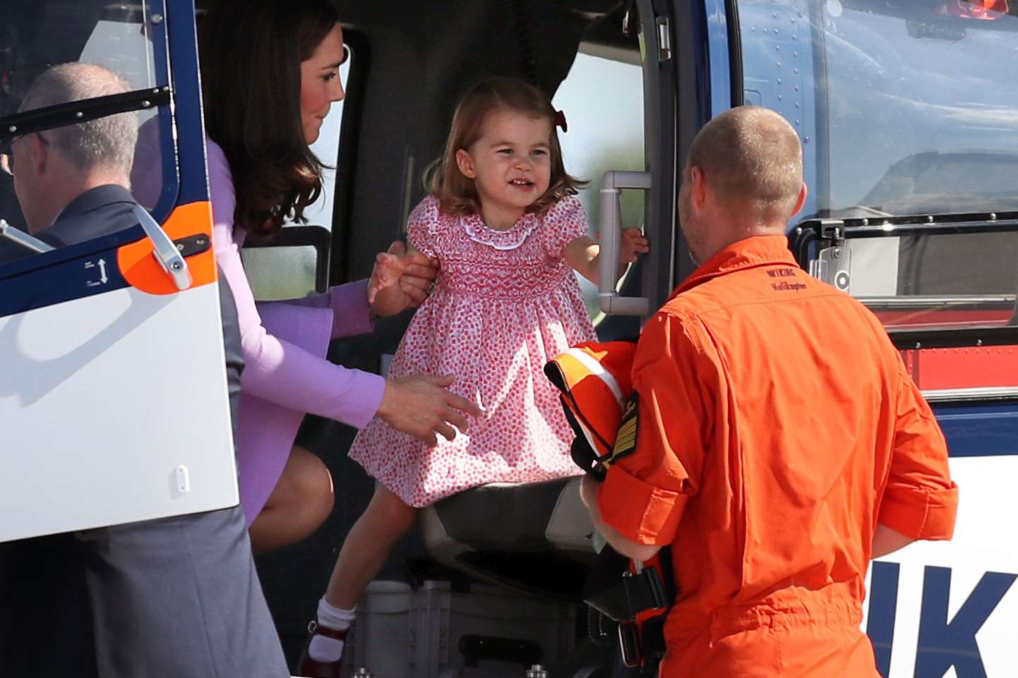 Princess Charlotte is helped from a helicopter on a royal visit