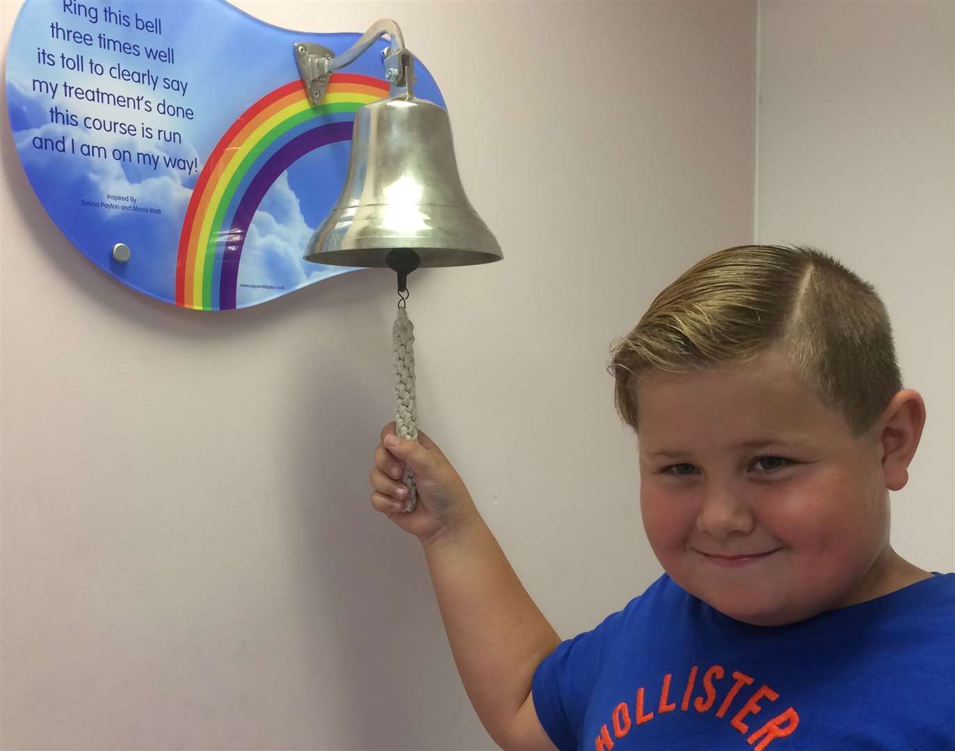 Aaron, 8, ringing the End of Treatment bell after being five years free of cancer