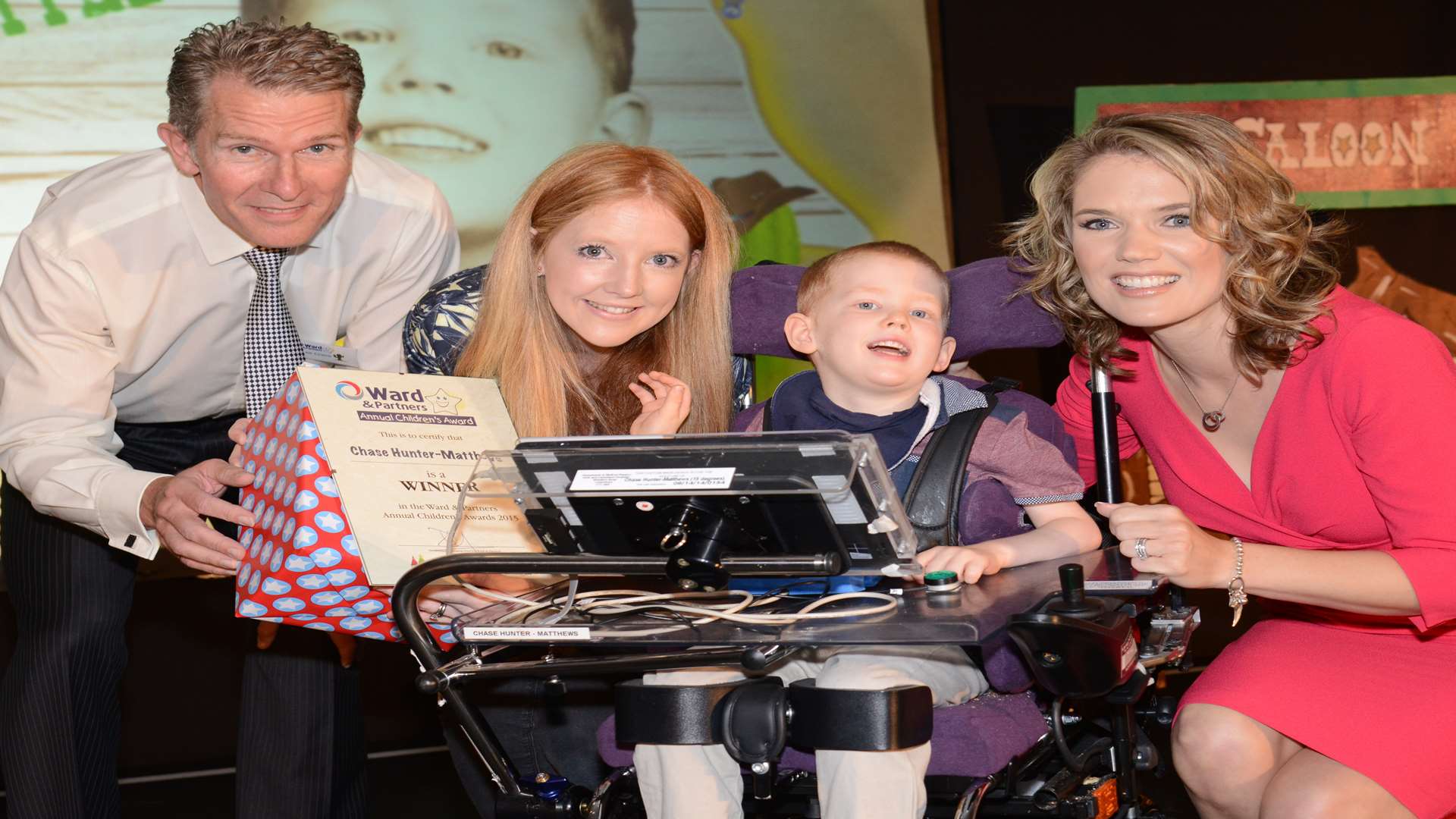 Charlotte Hawkins and Lee Crane, regional managing director for Ward & Partners, presenting award to Chase Hunter-Matthews and mum, Nikki Hunter-Pike