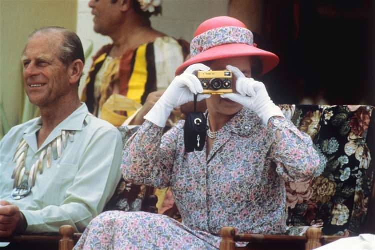 The Queen, whose portrait has hung on the walls of the gallery, taking photographs in 1982