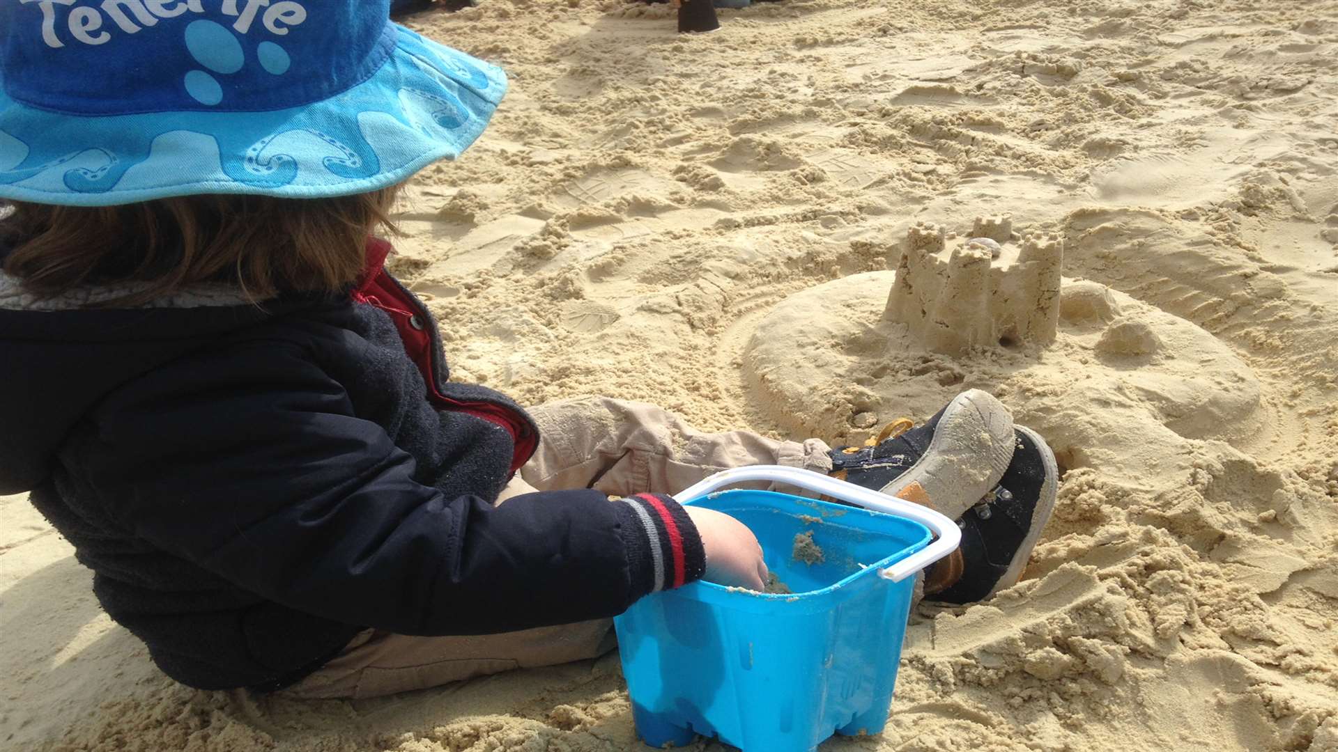 Ollie building sandcastles in the playground's sandpit