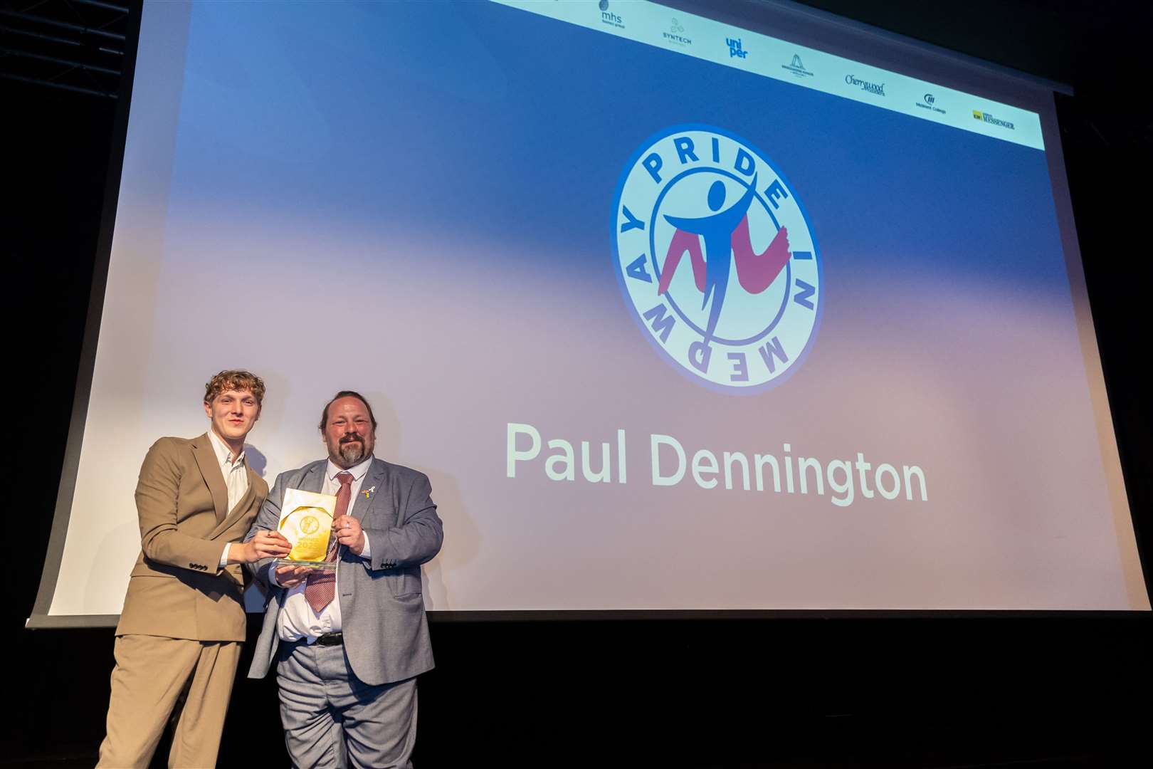 Paul Dennington from Hempstead was named overall winner at the Pride in Medway Awards 2025. Pictured: Paul’s son Joseph collecting the award on his behalf with Medway Council Leader Cllr Vince Maple