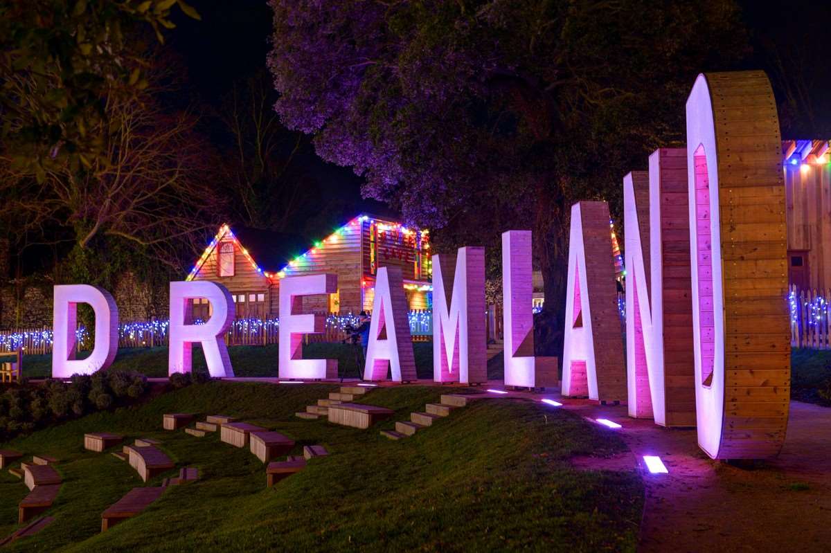 Santa's grotto can be seen lit up behind the Dreamland sign